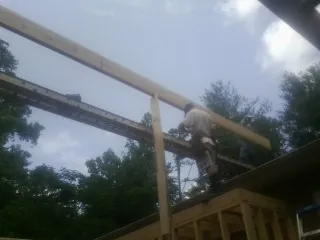 Carpenter setting a ridge beam over a new addition frame — Ice Dam Removal by Roofing Brothers in Dryden