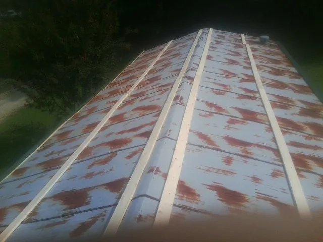 Rusted metal roof panels with new wood purlins before replacement — Storm Damage Roof Repair in Dryden by Roofing Brothers